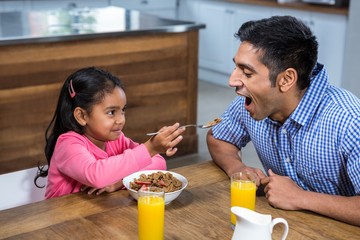 Cute daughter feeding his father
