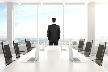 Businessman standing and looking out the window in the conferenc