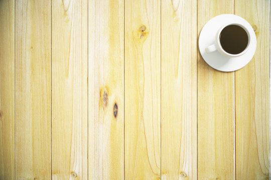 Top view of a wooden table with a cup of coffee