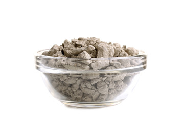 dry cosmetic clay in a bowl on white isolated background