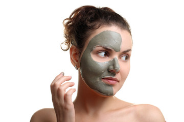 the woman deals on the face mask of healing clay on a white isolated background