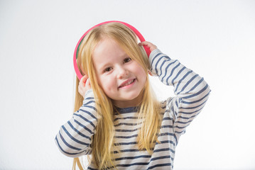 Little happy girl listening music on headphones