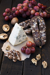 Snacks for wine, cheese with mold, pink grapes, walnuts