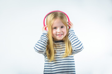 Little happy girl listening music on headphones