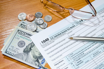deadline time of 1040 tax form for 2016 with dollar and pen