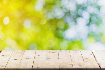 green bokeh and soft light in garden and wood table with space