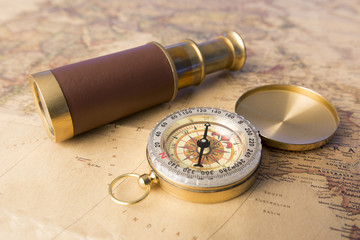 Old compass and old telescope on vintage map world explorer concept