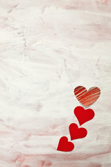 Postcard with with four handmade red hearts on grunge background