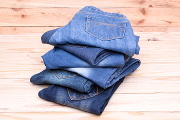 Piles of jeans on wooden background