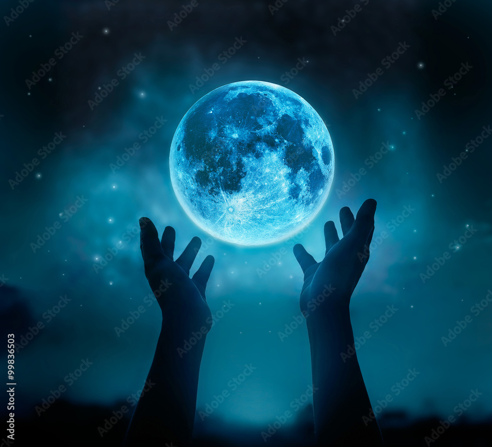Wall mural abstract hands while praying at blue full moon with star in dark background