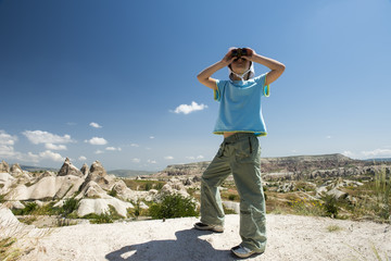 Small girl with binocular in mountains