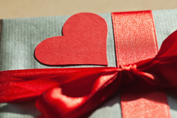 Fototapeta premium Valentine gift box wrapped in silver paper, with red bond and re
