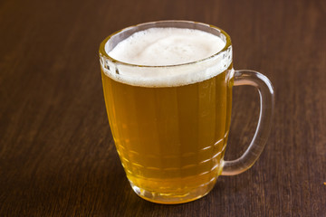 Mug of beer on wooden background