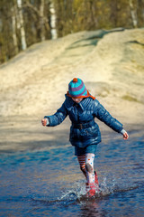 Girl running and jumping in puddle