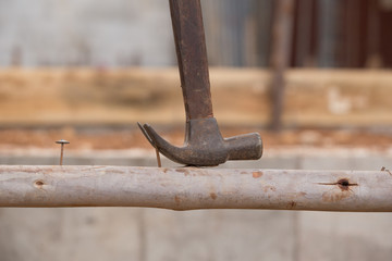 hammer pulling a nail out of wood