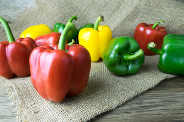 Colored bell peppers on wooden table
