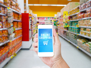 Hand holding  mobile phone  with Online shopping word with blur