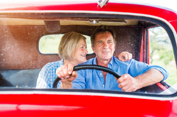 Senior couple in red car