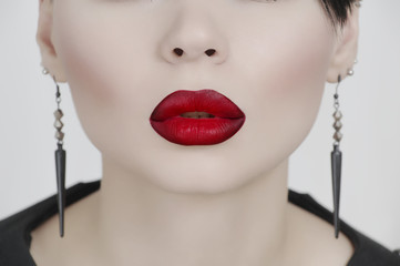 The face of a pretty girl with very white skin and red lips