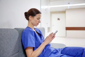 female doctor or nurse with smartphone at hospital