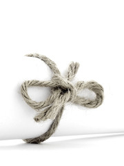 Handmade natural cord knot tied on white paper roll isolated