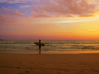 Black surfer silhouette at sunset ocean background
