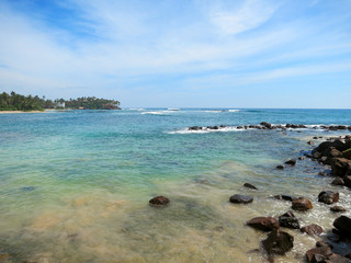 Fototapeta na wymiar Mirissa bay with rocks, greens and ocean waves, Sri Lanka