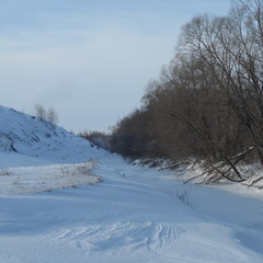 A winter nature, an icy river near the hill