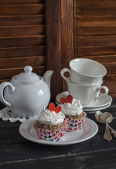 Valentine's day romantic Breakfast. Banana oat cupcakes and a tea set on a dark wooden table