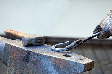 Blacksmith forges a horseshoe