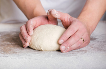 Close-up the hand of a baker kneading and shaping dough