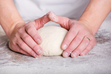 Close-up the hand of a baker kneading and shaping dough