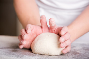 Close-up the hand of a baker kneading and shaping dough