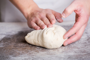 Close-up the hand of a baker kneading and shaping dough