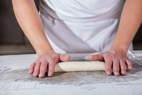 Close-up the hand of a baker kneading and shaping dough