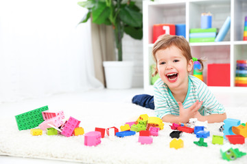 happy child laughing and playing with toys constructor