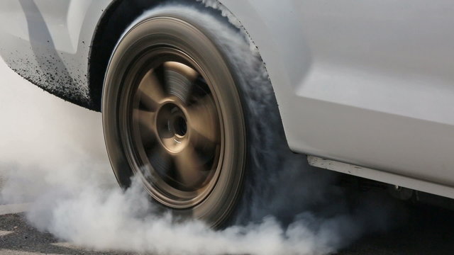 Drag racing car burns rubber off its tires
