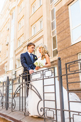 Bride and groom standing on the stairs.