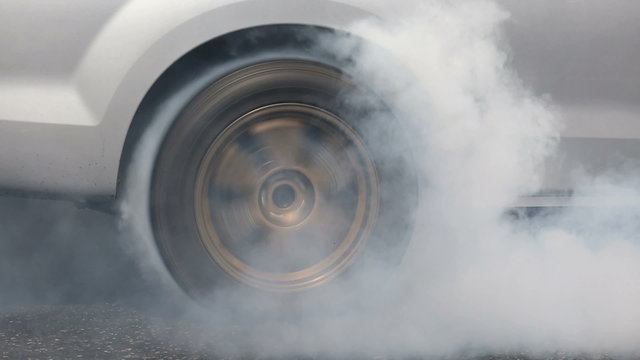 Drag racing car burns rubber off its tires