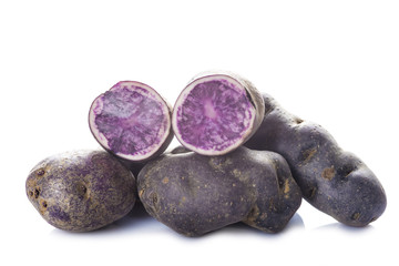 Patatas azules moradas o violetas aisladas sobre un fondo blanco