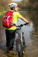 Men riding a bike helmet and a backpack.