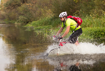Obraz premium Men riding a bike helmet and a backpack.