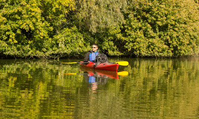 Men travel by canoe on the river in the summer.
