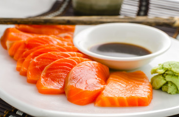 japanese food raw salmon red fish sashimi slices on a dish with sauce