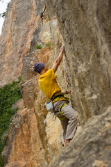 Obraz premium Young male climber hanging by a cliff.