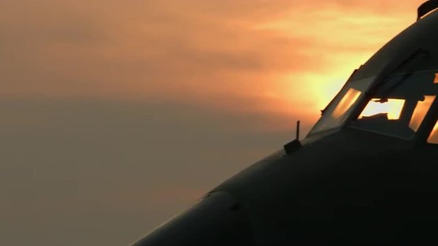 Pan across dawn sky to backlit cockpit of Transall C-160 military transport plane, developed by France and Germany.  Recorded in 4K, ultra high definition.