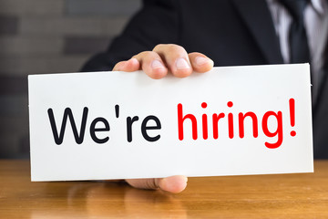 We are hiring, message on white card and hold by businessman
