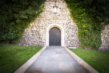 Small door at stone wall of old castle.