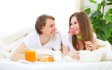 Obraz na płótnie Canvas loving couple having breakfast in bed