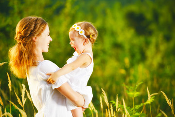 happy family, mother and little daughter child in summer meadow